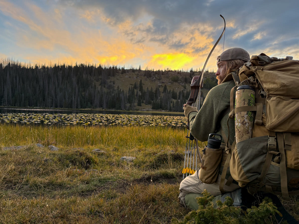 Hunter glassing a sheep herd across a meadow at golden hour sunset