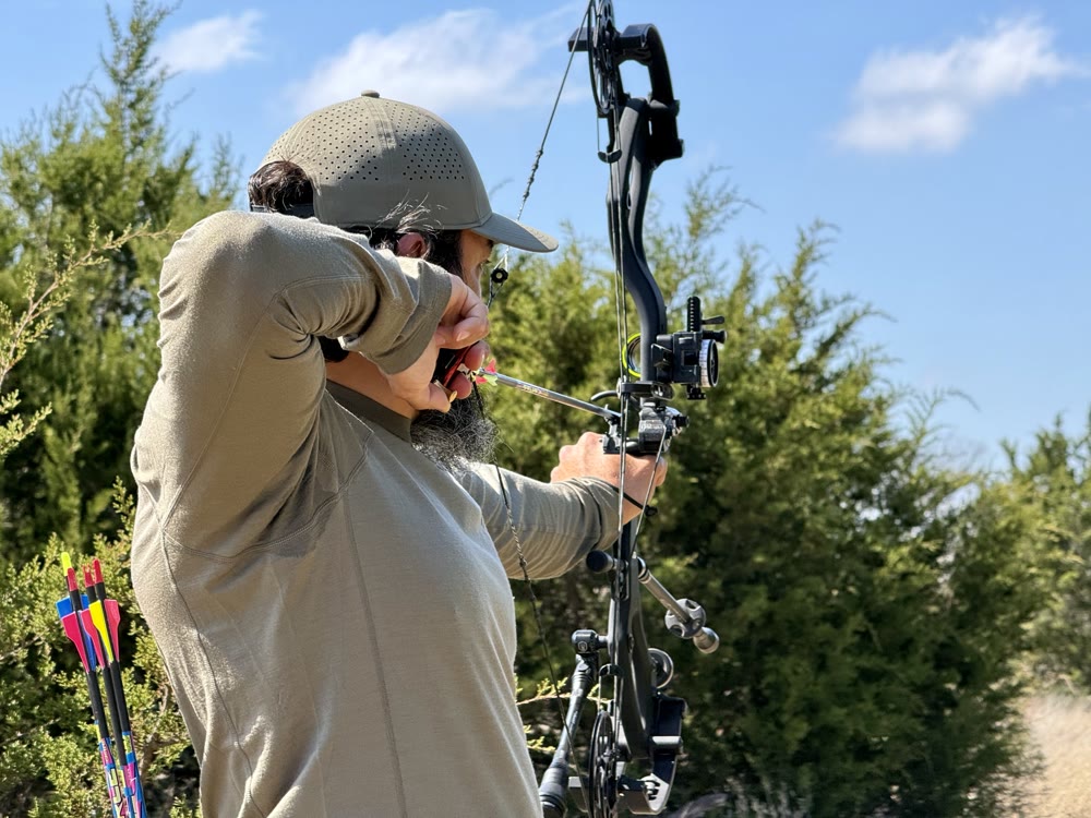 Archer at full draw, close-up, home practice