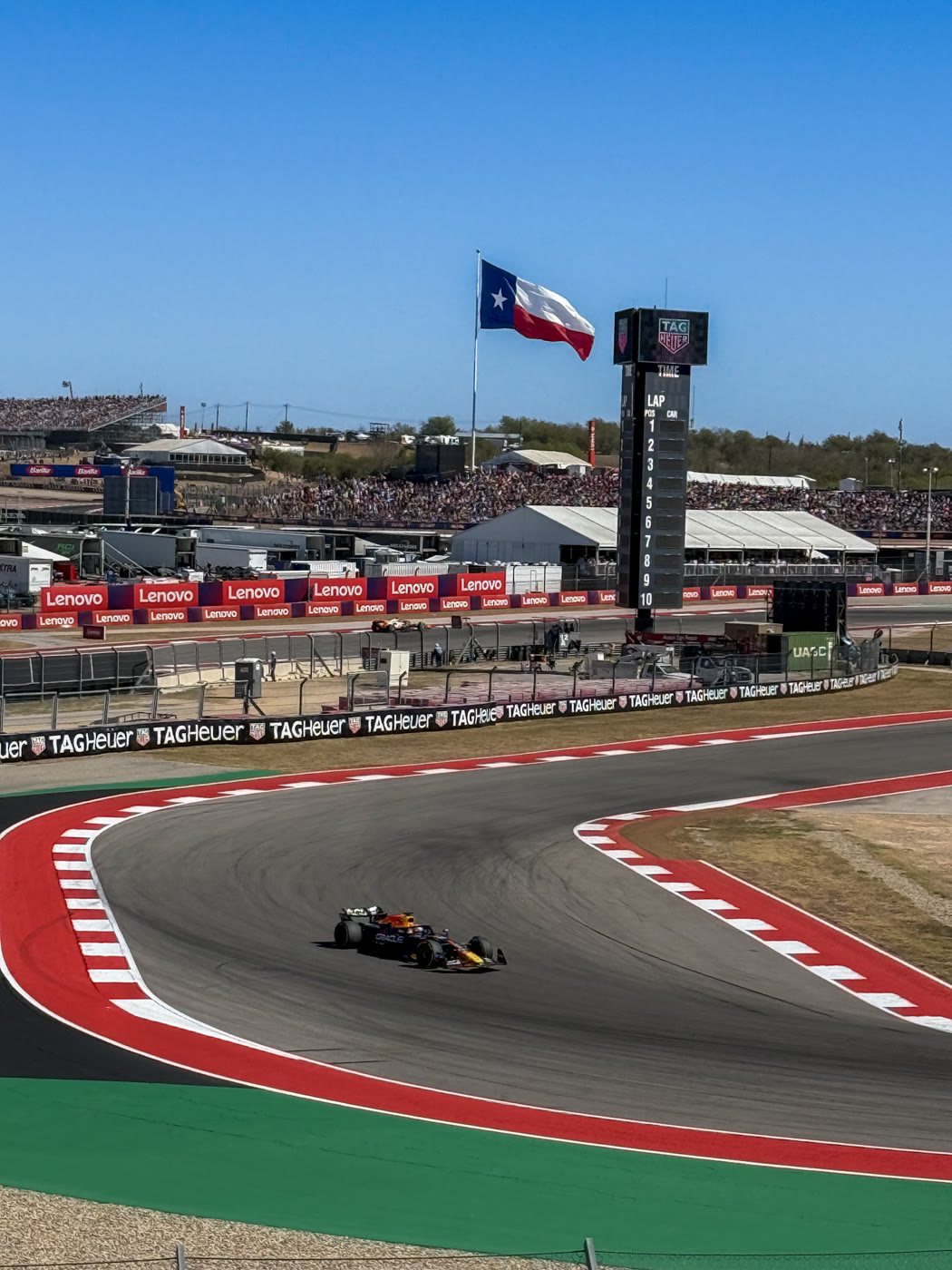 Red Bull F1 car at Circuit of the Americas with a Texas flag prominent in frame