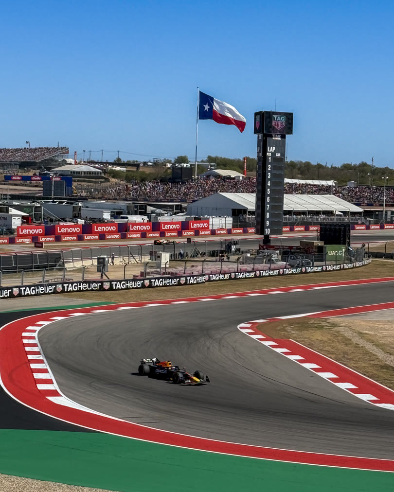 Red Bull F1 car at Circuit of the Americas with a Texas flag prominent in frame